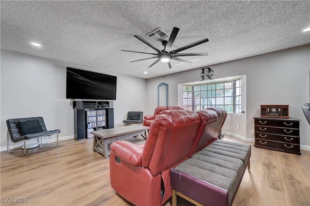 cinema featuring light wood-type flooring, a ceiling fan, baseboards, recessed lighting, and a textured ceiling