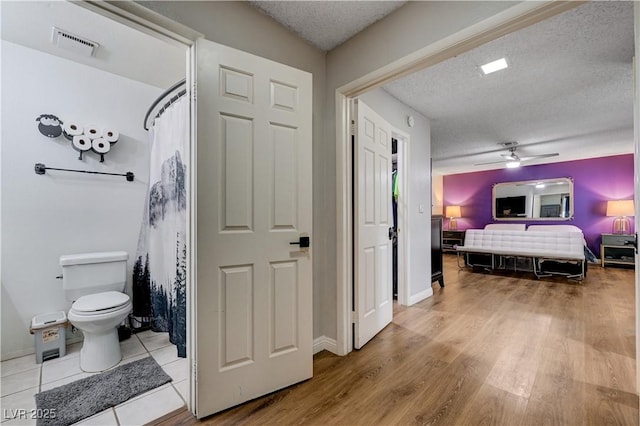 bedroom featuring a textured ceiling, wood finished floors, and ceiling fan