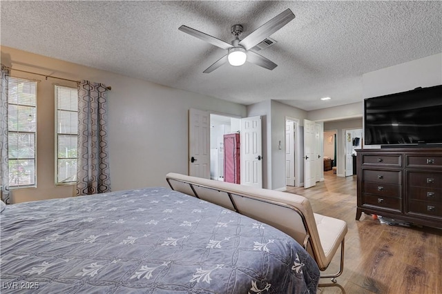 bedroom featuring wood finished floors, a textured ceiling, and ceiling fan