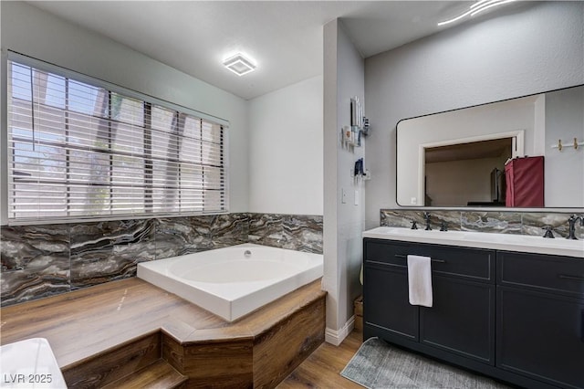 bathroom with double vanity, a bath, and wood finished floors