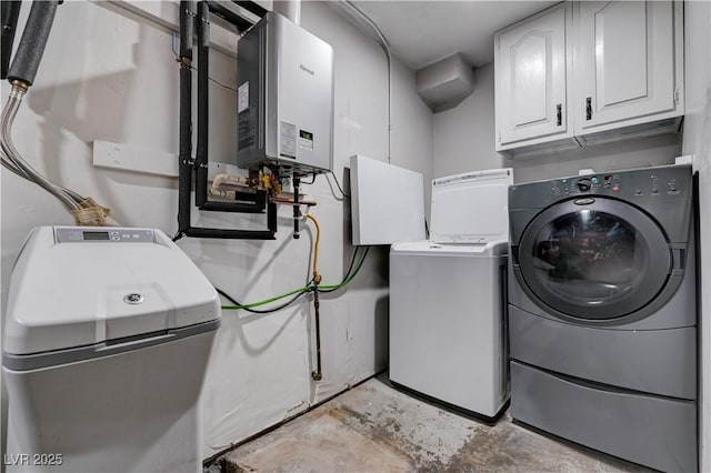laundry area featuring cabinet space, independent washer and dryer, and water heater