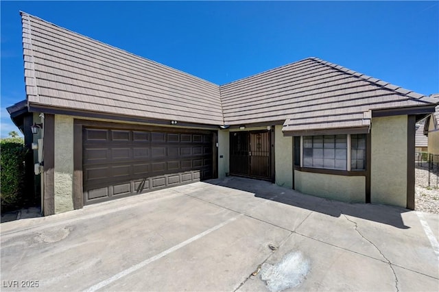 view of front facade with stucco siding, driveway, and a garage