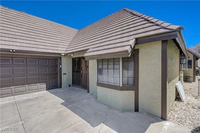 view of front of house featuring stucco siding, an attached garage, and concrete driveway
