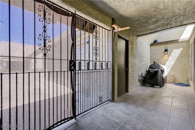 property entrance with stucco siding and a gate