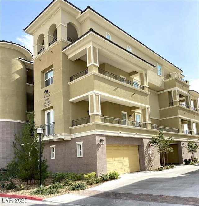 9125 Las Manaitas Ave Unit 302, Las Vegas, NV 89144 - view of apartment building / complex with a garage and driveway