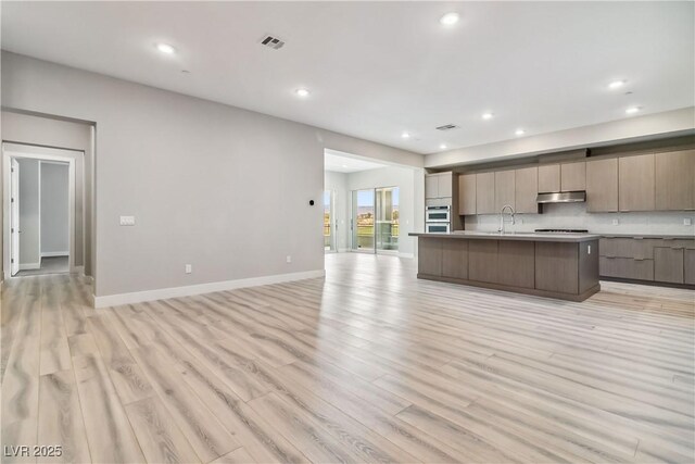 9125 Las Manaitas Ave Unit 302, Las Vegas, NV 89144 - kitchen with open floor plan, modern cabinets, light countertops, light wood-style floors, and recessed lighting