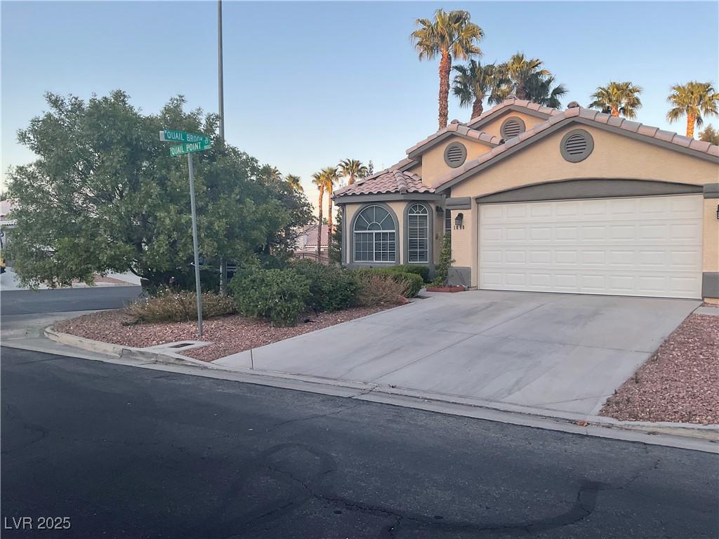 1800 Quail Point Ct, Las Vegas, NV 89117 - mediterranean / spanish house with an attached garage, stucco siding, driveway, and a tiled roof