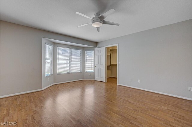 472 Staghorn Pass Ave, Las Vegas, NV 89183 - unfurnished bedroom featuring baseboards, light wood-type flooring, a spacious closet, and a ceiling fan
