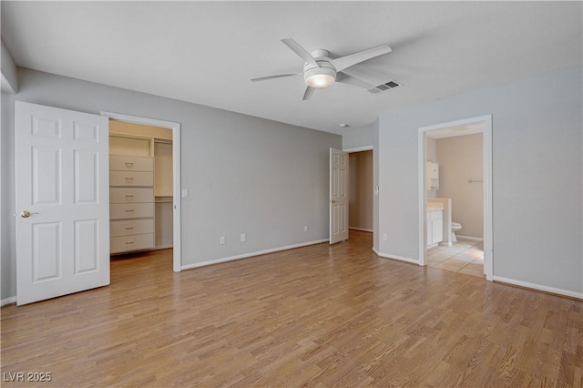 472 Staghorn Pass Ave, Las Vegas, NV 89183 - unfurnished bedroom with a walk in closet, light wood finished floors, baseboards, and ensuite bathroom