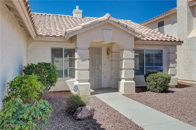 472 Staghorn Pass Ave, Las Vegas, NV 89183 - entrance to property with a tile roof, stucco siding, and a chimney