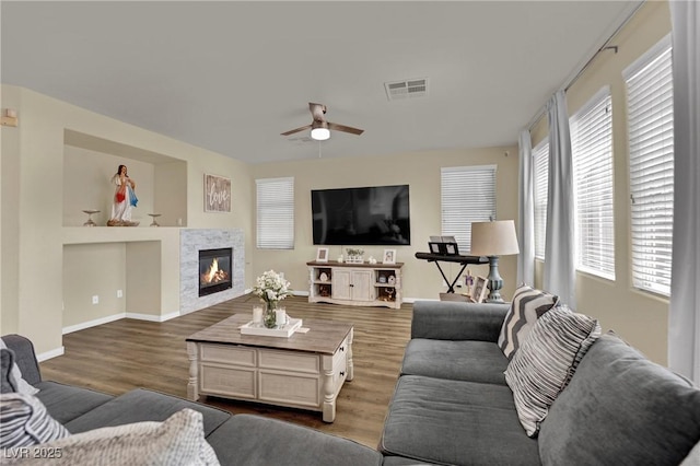 3217 Bonassola Ave, North Las Vegas, NV 89031 - living room featuring a ceiling fan, dark wood-style floors, baseboards, and a glass covered fireplace