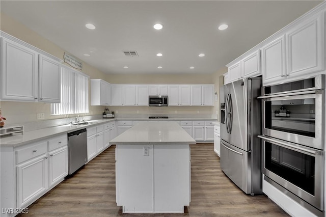3217 Bonassola Ave, North Las Vegas, NV 89031 - kitchen featuring appliances with stainless steel finishes, a kitchen island, light countertops, white cabinetry, and recessed lighting