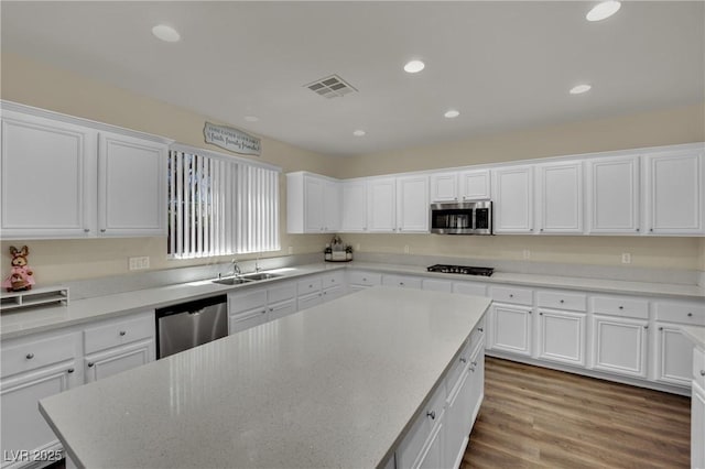3217 Bonassola Ave, North Las Vegas, NV 89031 - kitchen with stainless steel appliances, white cabinets, recessed lighting, a kitchen island, and a sink