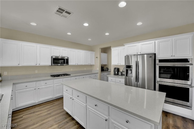 3217 Bonassola Ave, North Las Vegas, NV 89031 - kitchen with stainless steel appliances, white cabinetry, recessed lighting, a kitchen island, and dark wood-style flooring