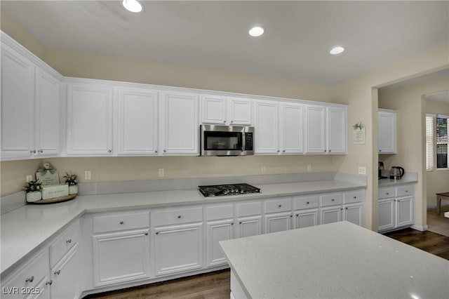 3217 Bonassola Ave, North Las Vegas, NV 89031 - kitchen with stainless steel microwave, white cabinetry, dark wood-style floors, gas stovetop, and recessed lighting