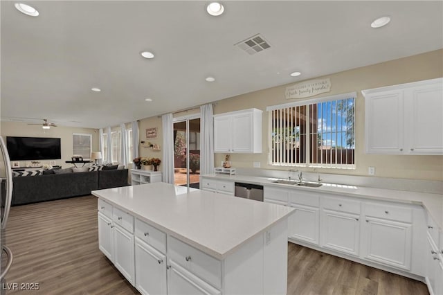 3217 Bonassola Ave, North Las Vegas, NV 89031 - kitchen with dishwasher, a sink, a kitchen island, recessed lighting, and wood finished floors