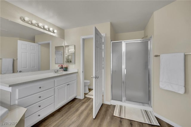 3217 Bonassola Ave, North Las Vegas, NV 89031 - bathroom featuring toilet, a stall shower, wood finished floors, and vanity