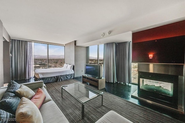 4381 W Flamingo Rd Unit 1101, Las Vegas, NV 89103 - living area featuring a wall of windows, a multi sided fireplace, and wood finished floors