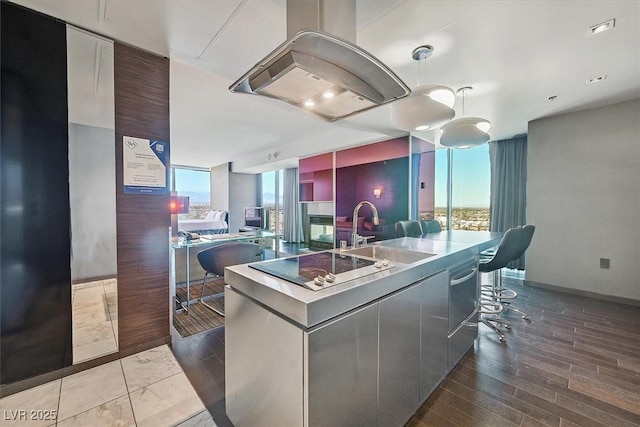 4381 W Flamingo Rd Unit 1101, Las Vegas, NV 89103 - kitchen with a sink, black electric cooktop, a kitchen island with sink, extractor fan, and modern cabinets