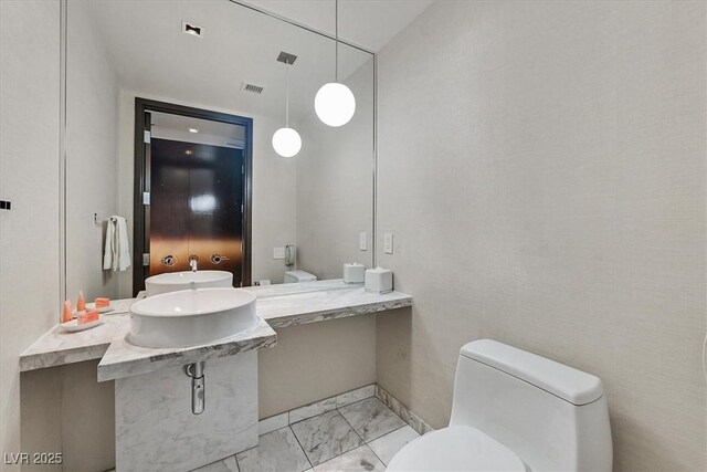 4381 W Flamingo Rd Unit 1101, Las Vegas, NV 89103 - bathroom featuring toilet and marble look tiles
