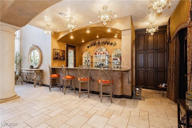 7625 Coley Ave, Las Vegas, NV 89117 - indoor dry bar with a chandelier, stone tile flooring, ornate columns, and recessed lighting