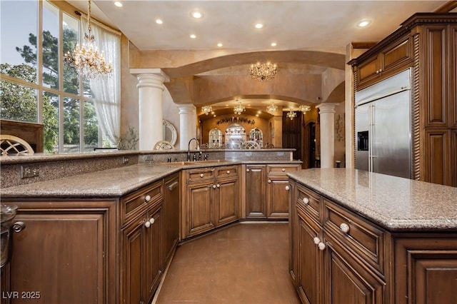 7625 Coley Ave, Las Vegas, NV 89117 - kitchen with decorative columns, stainless steel built in refrigerator, a chandelier, a center island, and arched walkways