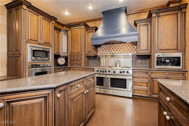 7625 Coley Ave, Las Vegas, NV 89117 - kitchen featuring premium range hood, appliances with stainless steel finishes, recessed lighting, decorative backsplash, and light stone counters