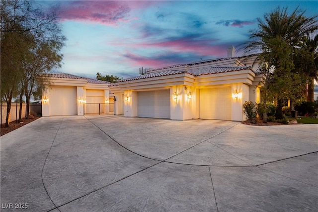 7625 Coley Ave, Las Vegas, NV 89117 - mediterranean / spanish home featuring driveway, an attached garage, a tiled roof, and stucco siding