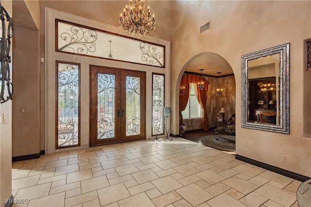 7625 Coley Ave, Las Vegas, NV 89117 - foyer featuring a chandelier, a towering ceiling, arched walkways, french doors, and baseboards