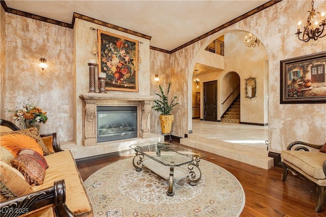 7625 Coley Ave, Las Vegas, NV 89117 - living room with arched walkways, a chandelier, a premium fireplace, wood finished floors, and stairs