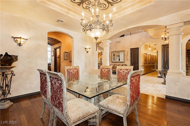 7625 Coley Ave, Las Vegas, NV 89117 - dining space with arched walkways, decorative columns, a chandelier, wood-type flooring, and a raised ceiling