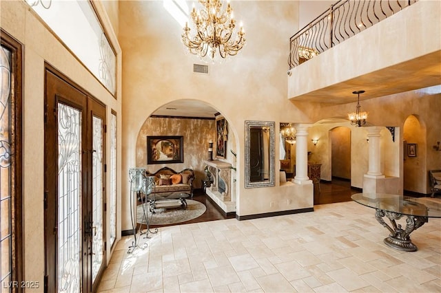 7625 Coley Ave, Las Vegas, NV 89117 - foyer entrance with arched walkways, a towering ceiling, a chandelier, and decorative columns