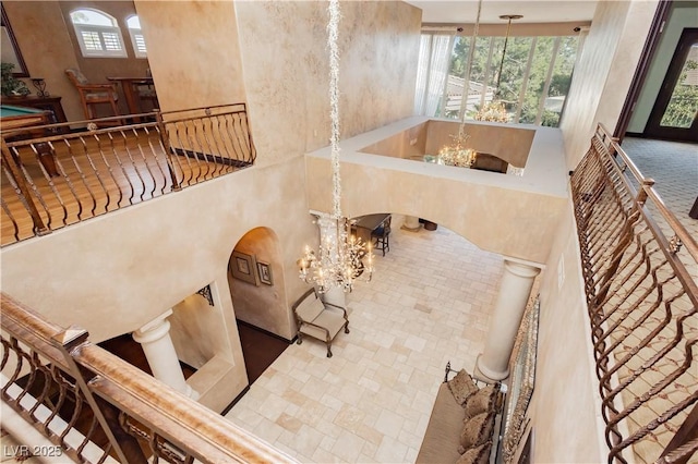 7625 Coley Ave, Las Vegas, NV 89117 - staircase with a chandelier, arched walkways, and a towering ceiling