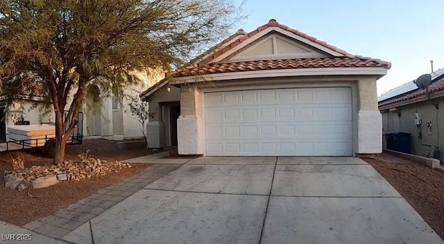 view of front facade featuring concrete driveway, stucco siding, a tile roof, and an attached garage