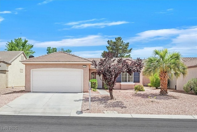 2573 Grandville Ave, Henderson, NV 89052 - view of front of house featuring concrete driveway, an attached garage, stucco siding, and a tiled roof