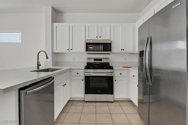 2573 Grandville Ave, Henderson, NV 89052 - kitchen with appliances with stainless steel finishes, a sink, light tile patterned floors, light countertops, and a peninsula