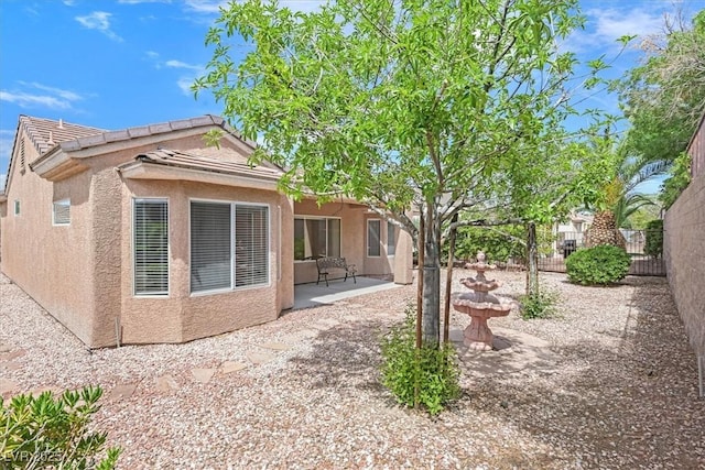 2573 Grandville Ave, Henderson, NV 89052 - rear view of house with a patio, fence, stucco siding, and a tile roof