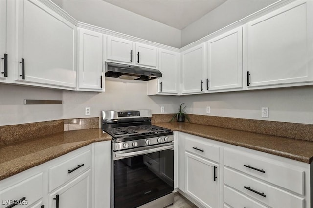 914 Appaloosa Hills Ave, North Las Vegas, NV 89081 - kitchen with stainless steel range with gas cooktop, under cabinet range hood, dark countertops, and white cabinetry