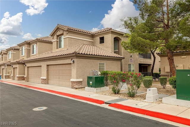 6655 Flaminian Ln Unit 104, North Las Vegas, NV 89084 - view of front of property featuring stucco siding, stone siding, and a tile roof