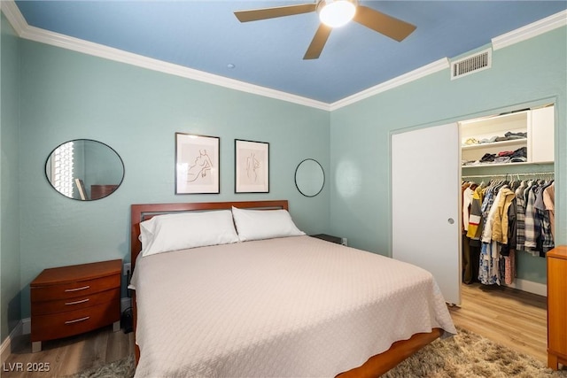 6655 Flaminian Ln Unit 104, North Las Vegas, NV 89084 - bedroom with wood finished floors, crown molding, a closet, baseboards, and a walk in closet