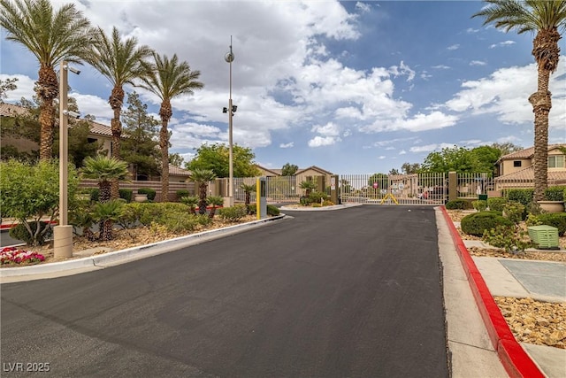 6655 Flaminian Ln Unit 104, North Las Vegas, NV 89084 - view of asphalt street featuring a gate, a residential view, curbs, and a gated entry