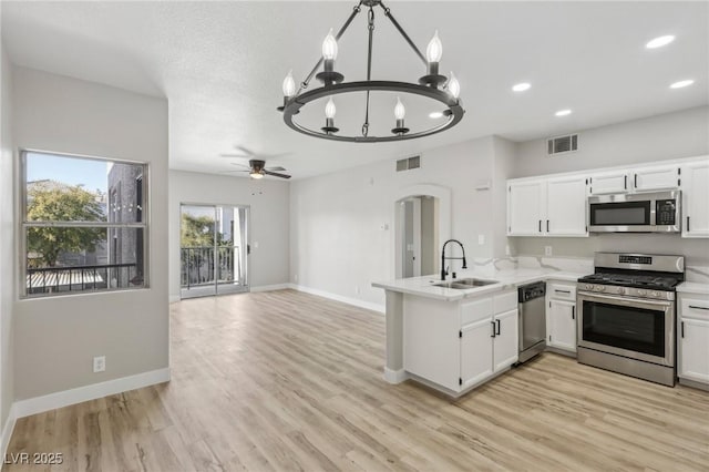2201 Ramsgate Dr Unit 327, Henderson, NV 89074 - kitchen with appliances with stainless steel finishes, a sink, a chandelier, a peninsula, and light countertops