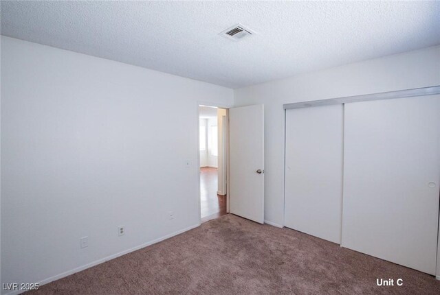 2755 Jennydiane Dr, Las Vegas, NV 89121 - unfurnished bedroom with carpet flooring, a closet, a textured ceiling, and baseboards
