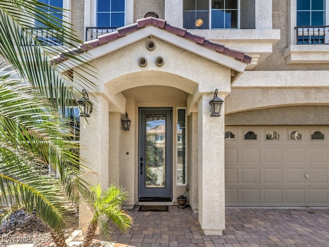 6779 Goose Watch Ct, Las Vegas, NV 89139 - doorway to property featuring a garage, stucco siding, a balcony, and driveway