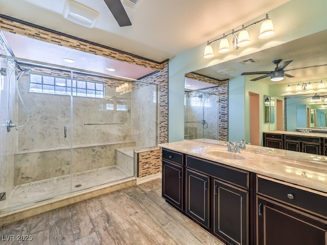 6779 Goose Watch Ct, Las Vegas, NV 89139 - full bath featuring ceiling fan, a shower stall, two vanities, and wood finished floors