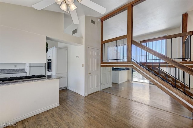 532 Greenbriar Pl, Boulder City, NV 89005 - unfurnished living room with ceiling fan, wood finished floors, high vaulted ceiling, baseboards, and stairway