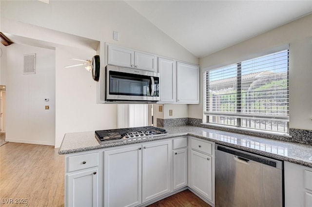 532 Greenbriar Pl, Boulder City, NV 89005 - kitchen with stainless steel appliances, vaulted ceiling, white cabinets, light wood-style floors, and a peninsula