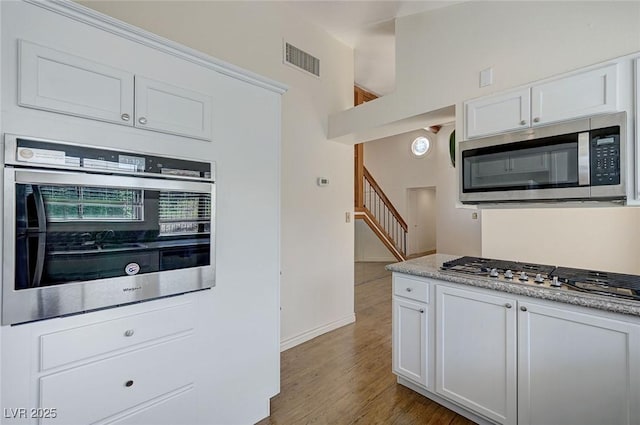532 Greenbriar Pl, Boulder City, NV 89005 - kitchen featuring appliances with stainless steel finishes, white cabinetry, baseboards, wood finished floors, and light countertops