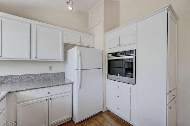 532 Greenbriar Pl, Boulder City, NV 89005 - kitchen with freestanding refrigerator, stainless steel oven, white cabinetry, and wood finished floors