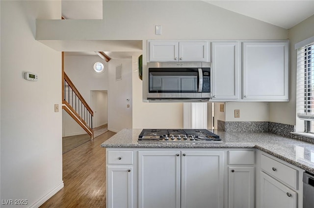 532 Greenbriar Pl, Boulder City, NV 89005 - kitchen featuring stainless steel appliances, white cabinetry, lofted ceiling, wood finished floors, and baseboards